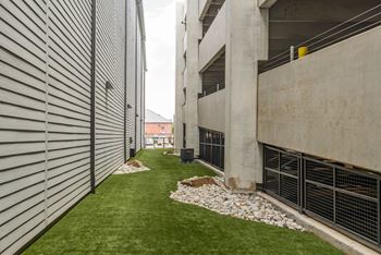 the side of a building with a grassy area in front of it